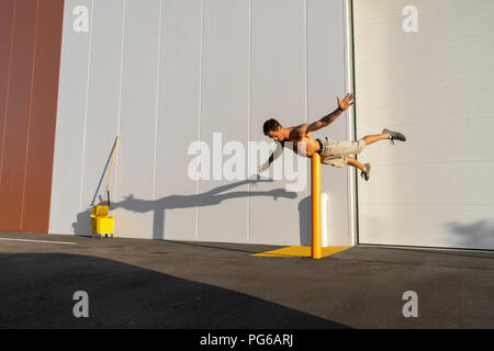 Acrobat Schulung auf einem Pfosten Stockfoto