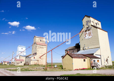 Mossleigh, Alberta, Kanada - 12. Juli 2018: altes verwittertes Holz Getreidesilos in der kleinen kanadischen Prairie Stadt Mossleigh, Alberta, Kanada. Stockfoto