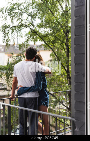 Ansicht der Rückseite des Paares in der Nachtwäsche stehen auf Balkon umarmen Stockfoto