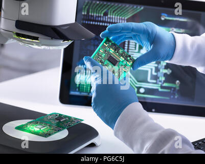 Techniker mit Hilfe eines 3-D Stereo Mikroskop für die Qualitätskontrolle in der Herstellung von Platinen für die Elektronikindustrie Stockfoto