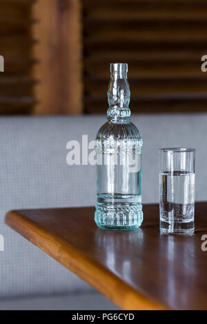 Glas Flasche mit frischem Trinkwasser auf dem hölzernen Tisch Stockfoto
