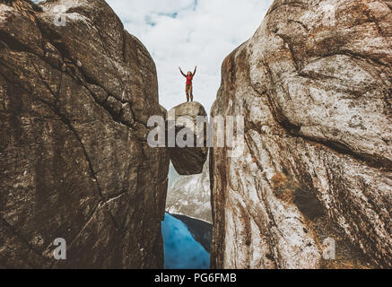 Mutige Frau Reisenden stehen auf Kjeragbolten erhobenen Händen Reisen in Norwegen Kjerag berge Sommer Ferien Abenteuer erfolg konzept Stockfoto