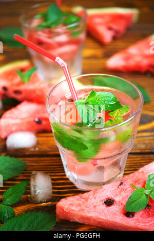 Sommer erfrischenden Cocktail der Wassermelone, grüne Minze und Eis Wasser auf einem hölzernen Hintergrund in ein Glas mit Frost Stockfoto