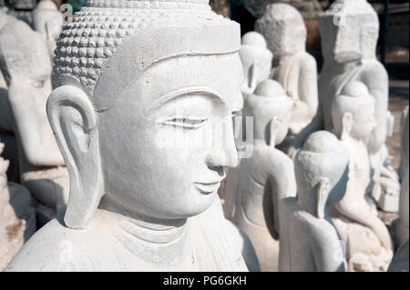 Nahaufnahme eines weißen Marmor Statue von Buddha Kopf mit weißer Marmor Buddha Statuen im Hintergrund Mandalay Myanmar Stockfoto