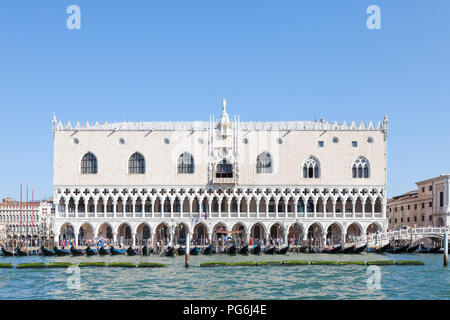 Dogen Palast, Palazzo Ducale, Palazzo Ducale, Piazza San Marco, Venedig, Venetien, Italien im Morgenlicht von der Lagune mit Gondeln und Touristen, blau Sonnig s Stockfoto