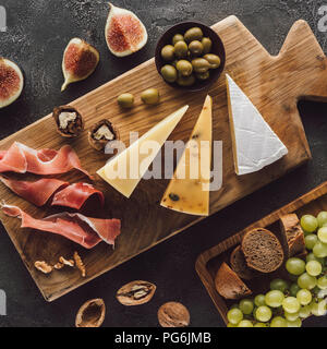 Flach mit verschiedenen Käse, Schinken und Obst auf dunklen Oberfläche Stockfoto