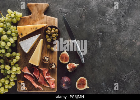 Flach mit verschiedenen Käse, jamon, Trauben und Feigen auf dunkle Oberfläche Stockfoto
