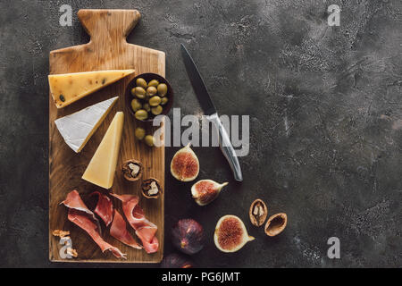 Flach mit verschiedenen Käse, Schinken und Feigen auf dunkle Oberfläche Stockfoto