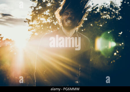 Heavy Metal Fan Headbangen in einem Park Stockfoto