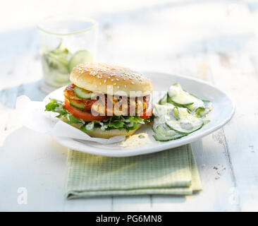 Chickenburger mit Gurkensalat und Joghurt Sauce Stockfoto