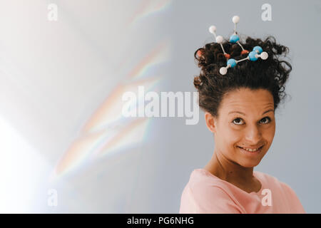 Junge Frau mit Molekül Modell im Haar Stockfoto