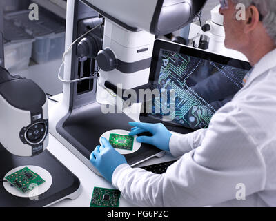 Techniker mit Hilfe eines 3-D Stereo Mikroskop für die Qualitätskontrolle in der Herstellung von Platinen für die Elektronikindustrie Stockfoto