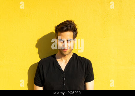 Mann, der vor der gelben wand, Porträt Stockfoto
