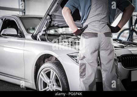 Modernes Auto Garantie beheben. Mechaniker vor dem Fahrzeug in der autorisierten Service Center. Stockfoto