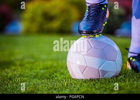 Fußball-Fußball-Spieler halten Steckvorrichtung an der Kugel. Closeup Foto. Fußball-Thema. Stockfoto