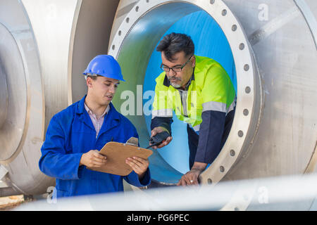 Arbeitnehmer in einem Tank im Gespräch mit Mitarbeiter Stockfoto