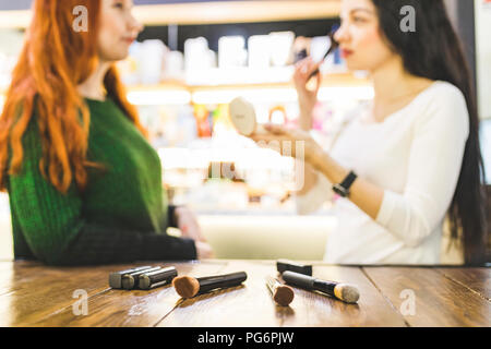 Zwei Frauen in einem kosmetik Shop versuchen, bilden. Stockfoto