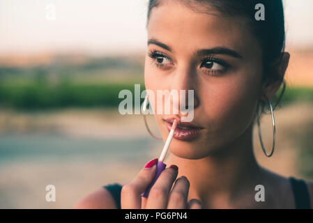 Portrait von Teenager in der Natur der Anwendung Lip Gloss Stockfoto