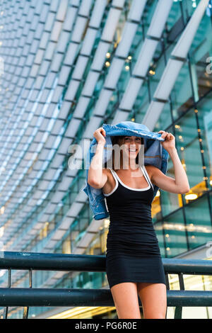 Porträt der glückliche junge Frau mit schwarzen Kleid in die Stadt in der Dämmerung Stockfoto