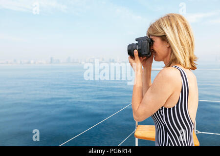 Reife Frau auf Segeltörn fotografieren Skyline von Barcelona Stockfoto