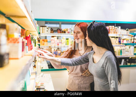 Zwei Frauen in einem kosmetik Shop diskutieren Produkte Stockfoto