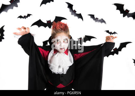 Scary Halloween vampir Boy für gruselige Halloween Party gekleidet und eine orange halloween kürbis jack o lantern Holding Stockfoto