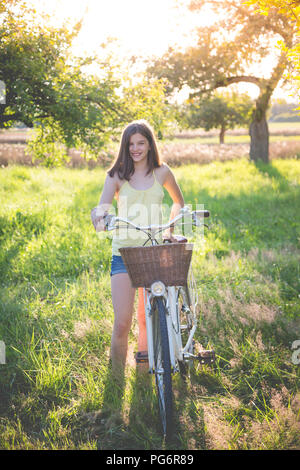 Portrait von lächelnden Mädchen mit dem Fahrrad in der Natur Stockfoto