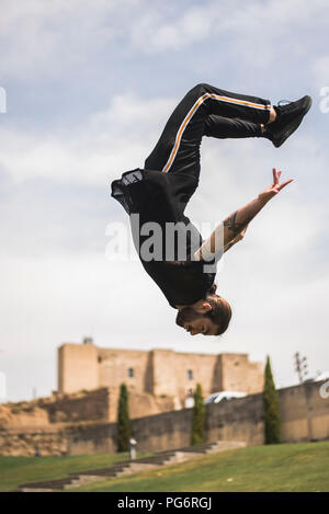 Spanien, Lleida, tätowierten Mann tun Parkour in einem Park Stockfoto