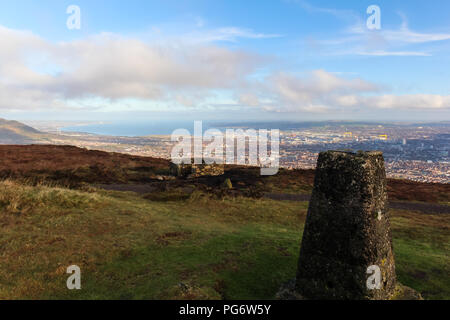 Anzeigen von trig Point auf dem Gipfel des Schwarzen Berges mit Blick auf Belfast City Belfast Lough und Stockfoto