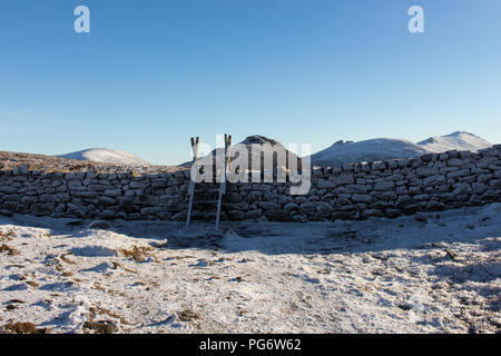 Schnee verkrustete Mourne Wall und Holm zu Herzen der Mourne Mountains mit Doan Berge in der Ferne. Stockfoto