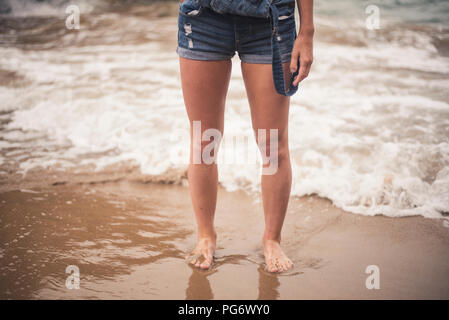 Beine der jungen Frau im Wasser am Strand Stockfoto