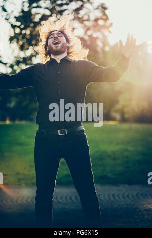 Heavy Metal Fan Headbangen in einem Park Stockfoto