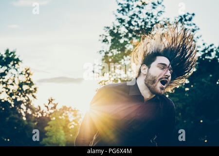 Heavy Metal Fan Headbangen in einem Park Stockfoto