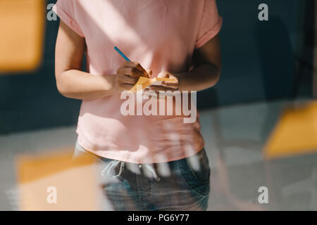 Frau Brainstorming in Office usine Haftnotizen Stockfoto