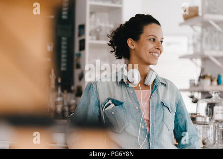 Junge Frau mit Kopfhörer, arbeiten in Coworking Space Stockfoto