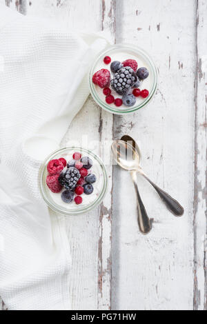 Zwei Gläser griechischer Joghurt mit gefrorenen Beeren Stockfoto