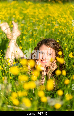 Junge Frau liegend auf Blumenwiese Stockfoto