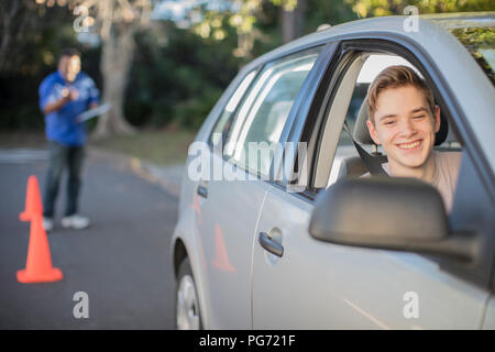 Lächelnd Fahrschüler lernen zu fahren im Rückspiegel eines Autos suchen Stockfoto