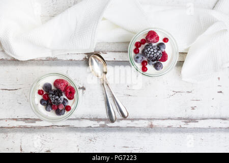 Zwei Gläser griechischer Joghurt mit gefrorenen Beeren Stockfoto