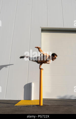 Acrobat Schulung auf einem Pfosten Stockfoto