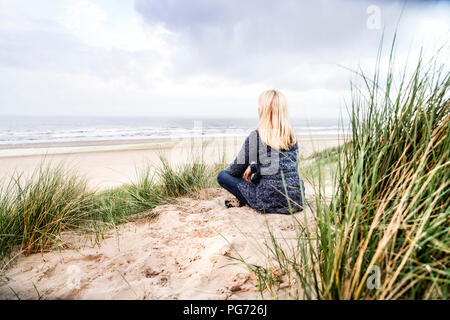 Die Frau in den Dünen sitzen Stockfoto