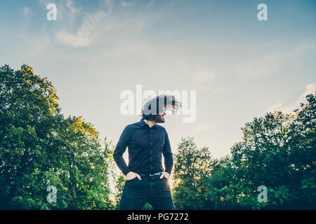 Heavy Metal Fan Headbangen in einem Park Stockfoto