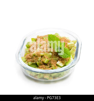 Gehackte Rhabarber mit braunem Zucker isoliert auf Weiss. Bereit zum Backen. Stockfoto