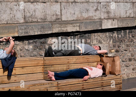 Menschen Schlafen oder Ruhen auf einer Bank durch den Fluss Seine in Paris, Frankreich Stockfoto