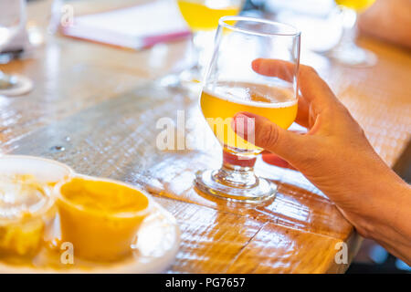 Weibliche Hand Glas Micro Brew Bier an der Bar. Stockfoto