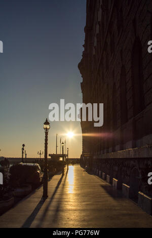 Die Außenseite des Bahnhof Haydarpasa in Istanbul, mit Blick auf den Sonnenuntergang, mit Lampen auf der linken Seite. Haydarpasa ist einer der größten Bahnhöfe Stockfoto