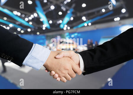Auto-Geschäft, Autoverkauf, Deal, Geste und Menschen Konzept - Nähe bis der männlichen Handshake Automesse oder Salon. Stockfoto