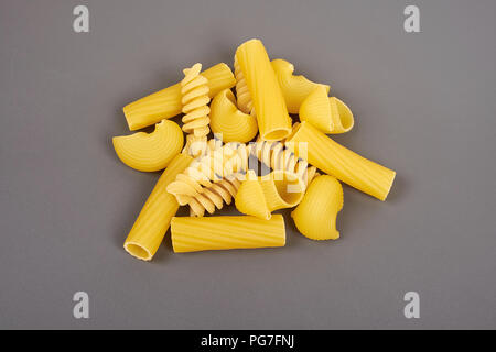 Verschiedene Arten von Pasta isoliert auf Grau Stockfoto