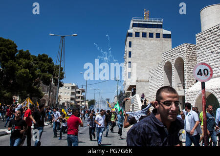 Bethlehem, Palästina, 1. August 2014: Palästinenser escape Tränengas Schuß durch die israelischen Streitkräfte während der Demonstration gegen Israel auf einer Straße in Fr Stockfoto