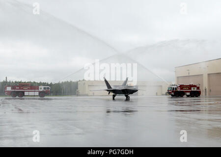 Luftwaffe Generalleutnant Ken Wilsbach erhält einen zeremoniellen Wasser salute in seiner F-22 Raptor während seiner letzten Flug als Kommandeur der alaskischen Befehl, Alaskan North American Aerospace Defense Region und Elften Luftwaffe, an Joint Base Elmendorf-Richardson, Alaska, Aug 20., 2018. Wilsbach ist ein Befehl Pilot mit mehr als 5.000 Flugstunden, vor allem in der F-15C, MC-12 und F-22, und hat 71 Einsätze in der nördlichen, südlichen Beobachten und Enduring Freedom geflogen. (U.S. Air Force Foto von Alejandro Peña) Stockfoto